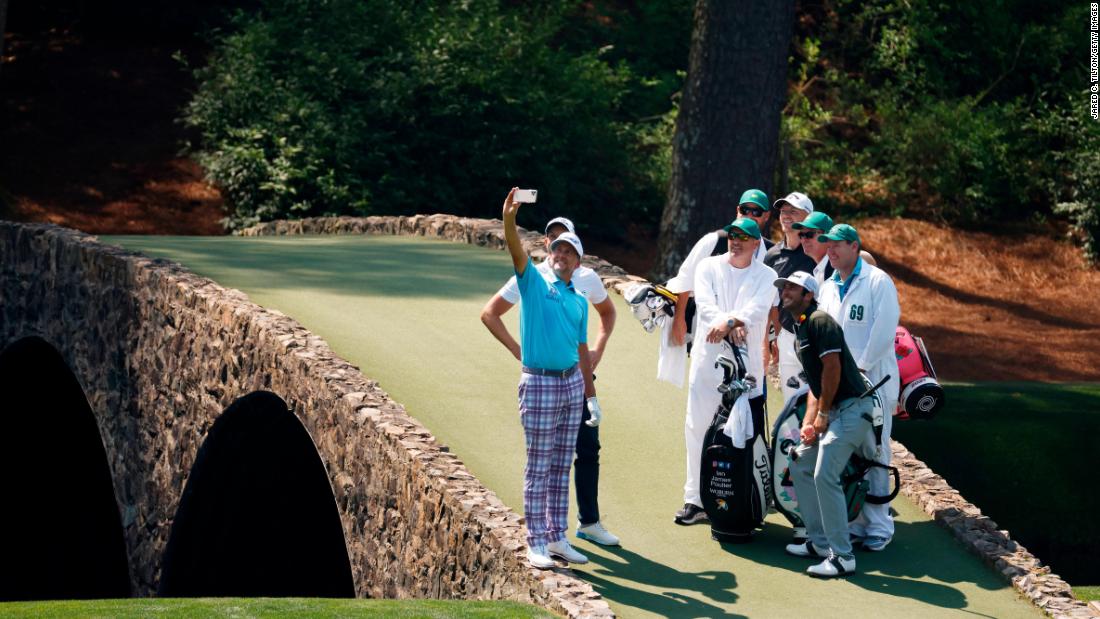 During a practice round on Wednesday, Ian Poulter takes a Hogan Bridge selfie with his playing partners and their caddies.
