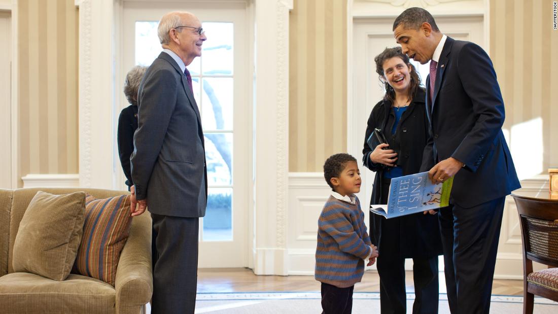 President Barack Obama reads from his book, &quot;Of Thee I Sing: A Letter to My Daughters,&quot; as Breyer and some of his family members visit the White House Oval Office in May 2011. Joining Breyer, from left, are his wife, Joanna; his grandson Eli; and his daughter Nell.