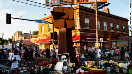 A sculpture of a raised fist stands in a memorial for George Floyd outside Cup Foods.