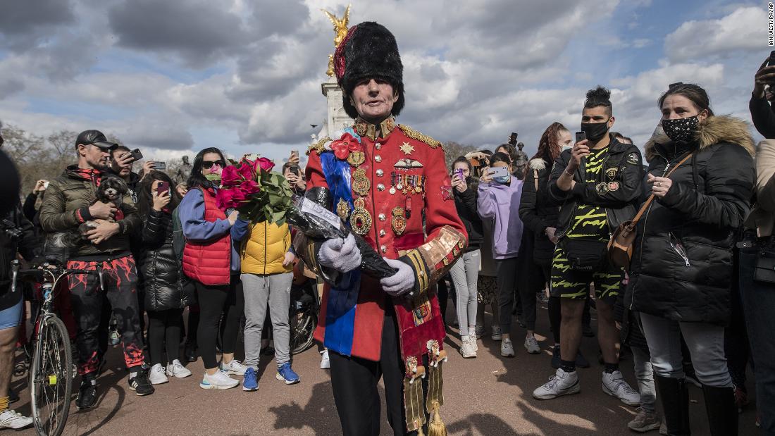 A man arrives to lay flowers outside London&#39;s Buckingham Palace on Friday, April 9.