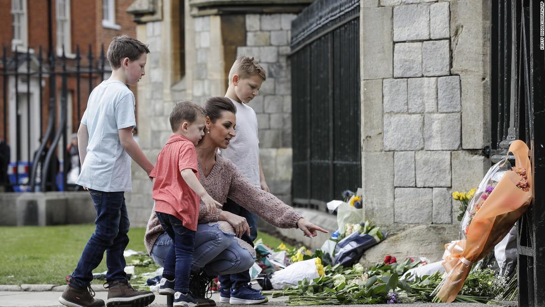 A family looks at flowers outside Windsor Castle on Friday.