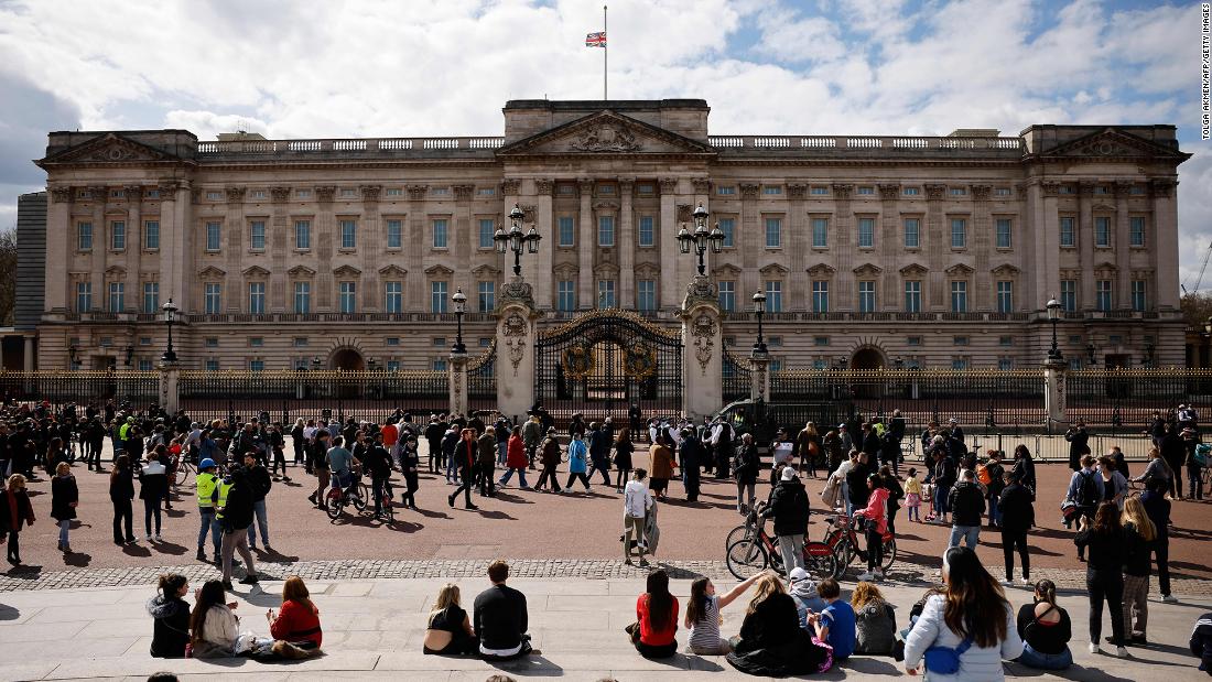 People gather outside Buckingham Palace, where the flag was flying at half-staff.