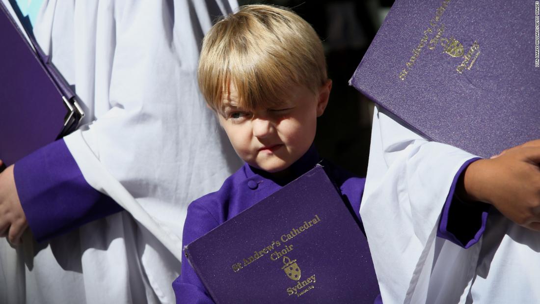A young member of the St. Andrew&#39;s Cathedral choir squints in the sunlight following the commemorative service in Sydney.