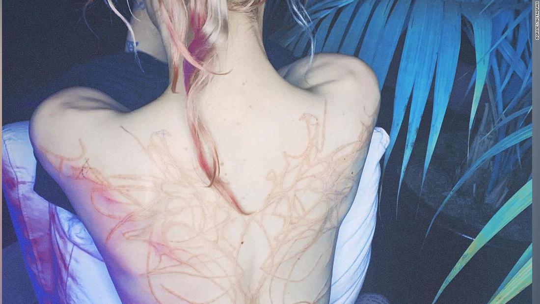 Grimes shows off the 'beautiful alien scars' she's had tattooed across her back