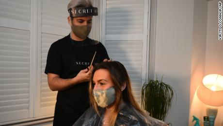 Secret Spa hair stylist Nas Ganev cuts the hair of Amy Pallister, 27, just after midnight on Monday. 