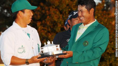 Matsuyama poses with his caddie, Hayafuji, and the Masters trophy.