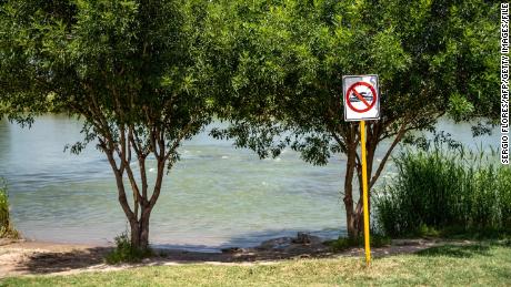 This file photo from 2019 shows a &quot;No Swimming&quot; sign near the Rio Grande in Piedras Negras, Mexico. The mother we met told us her family was on the banks of the river in Piedras Negras when they decided to separate.