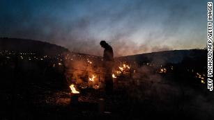 A winegrower from the Daniel-Etienne Defaix wine estate lights candles in a vineyard near Chablis, Burgundy.