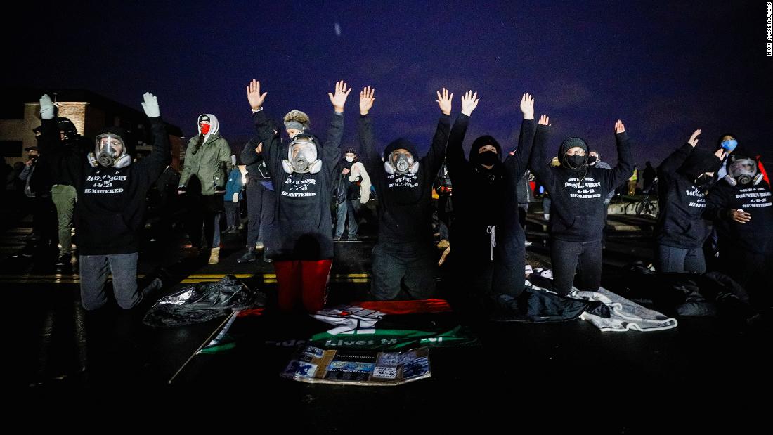 Activists raise their arms as they confront State troopers, National Guard members, and other law enforcement officers on Tuesday.