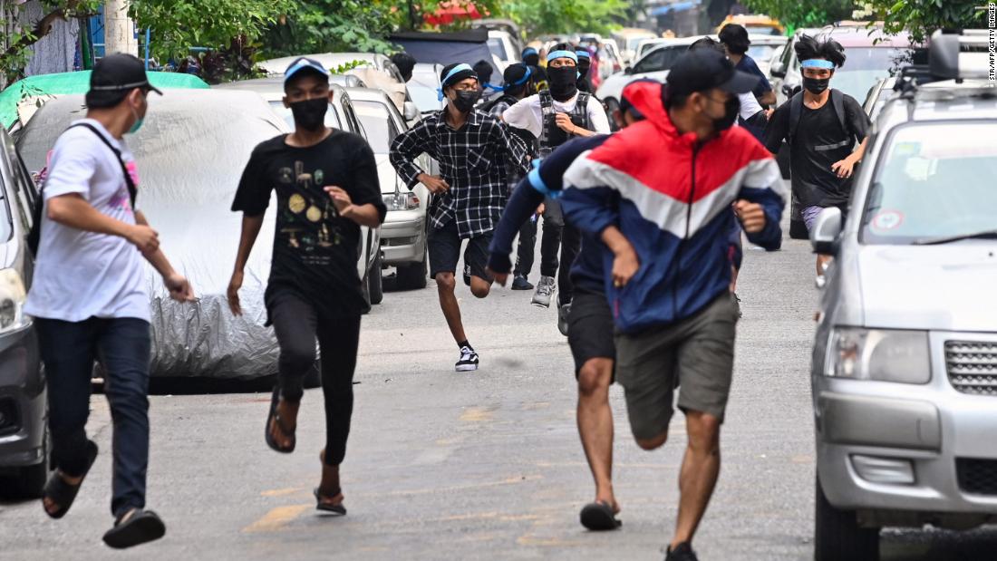 Protesters run from security forces during an anti-coup demonstration in Yangon on April 12.