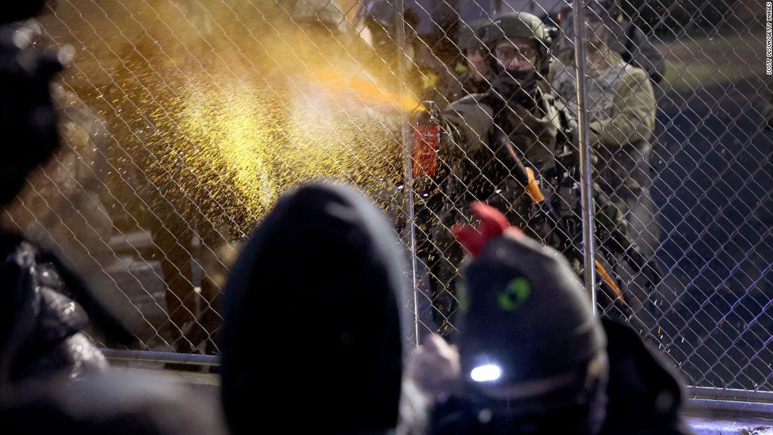 A police officer pepper-sprays demonstrators on Tuesday.