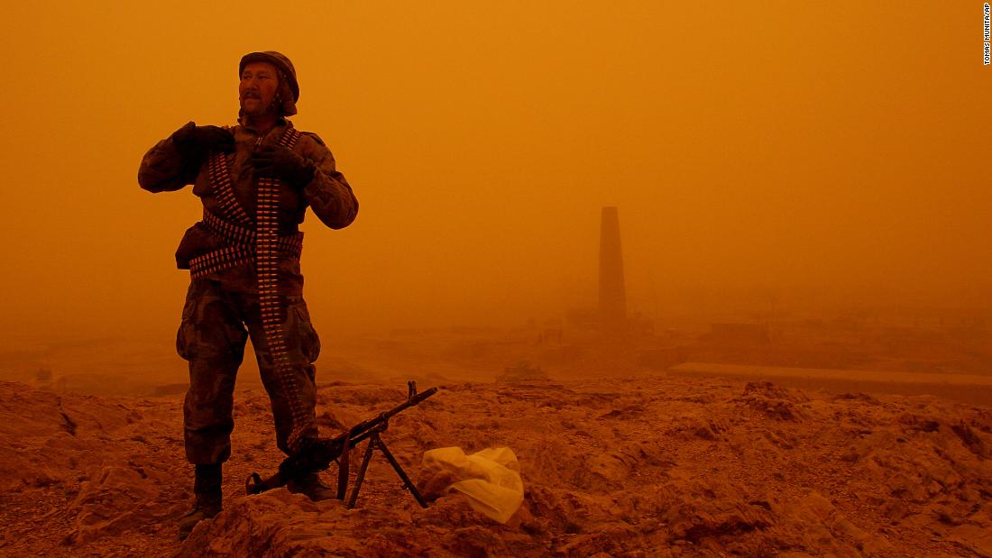 An Afghan soldier provides security at the site where a US helicopter crashed near Ghazni, Afghanistan, in April 2005. At least 16 people were killed.