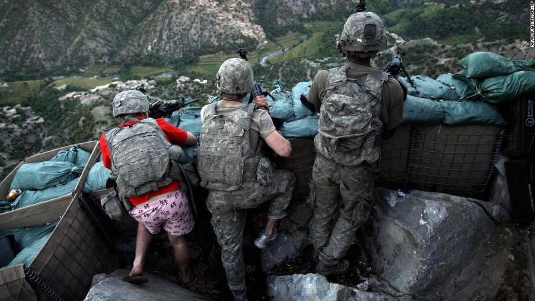 US soldiers take defensive positions after receiving fire from Taliban positions in Afghanistan&#39;s Korengal Valley in May 2009. Army Spc. Zachary Boyd was still in his &quot;I love NY&quot; boxers because he rushed from his sleeping quarters to join his fellow platoon members. 