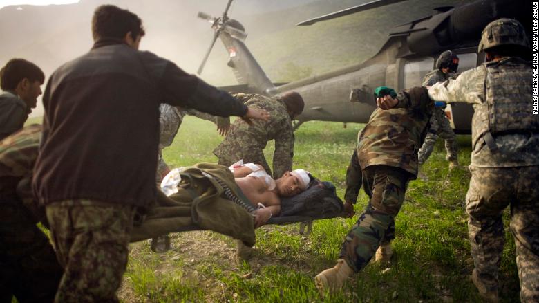 Afghan soldiers rush a wounded police officer to an American helicopter in Afghanistan&#39;s Kunar province in March 2010.