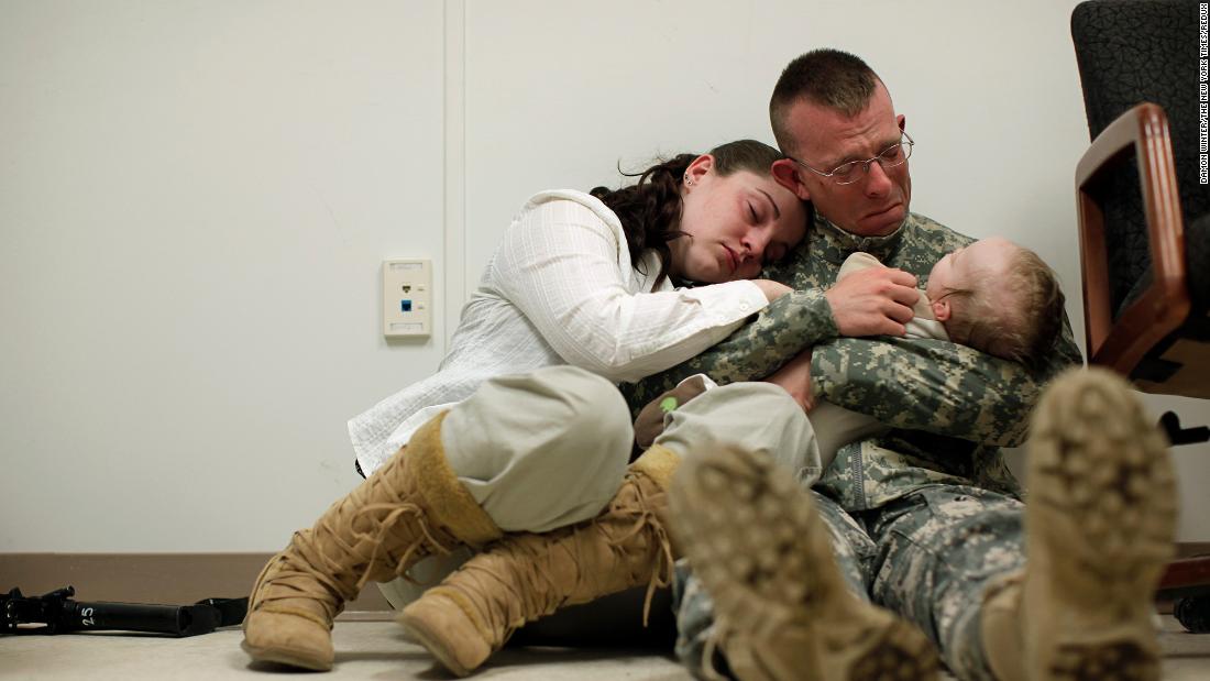 Sgt. Brian Keith sits with his wife, Sara, and their baby son, Stephen, just before his deployment to Afghanistan in March 2010. A few months earlier, President Barack Obama announced a surge of 30,000 additional troops. This new deployment would bring the US total to almost 100,000 troops, in addition to 40,000 NATO troops. 