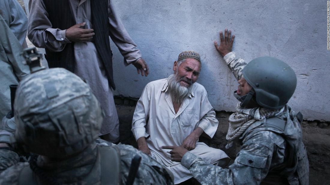 A man cries while talking to US soldiers in Naghma Bazaar, Afghanistan, in September 2010. The man said Taliban fighters had forced their way into his home and demanded food and milk before getting into a firefight with American soldiers.