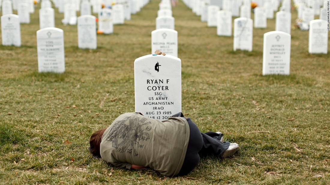 Lesleigh Coyer lies down in front of the grave of her brother, Army Staff Sgt. Ryan Coyer, at Virginia&#39;s Arlington National Cemetery in March 2013. He died of complications from an injury sustained in Afghanistan.