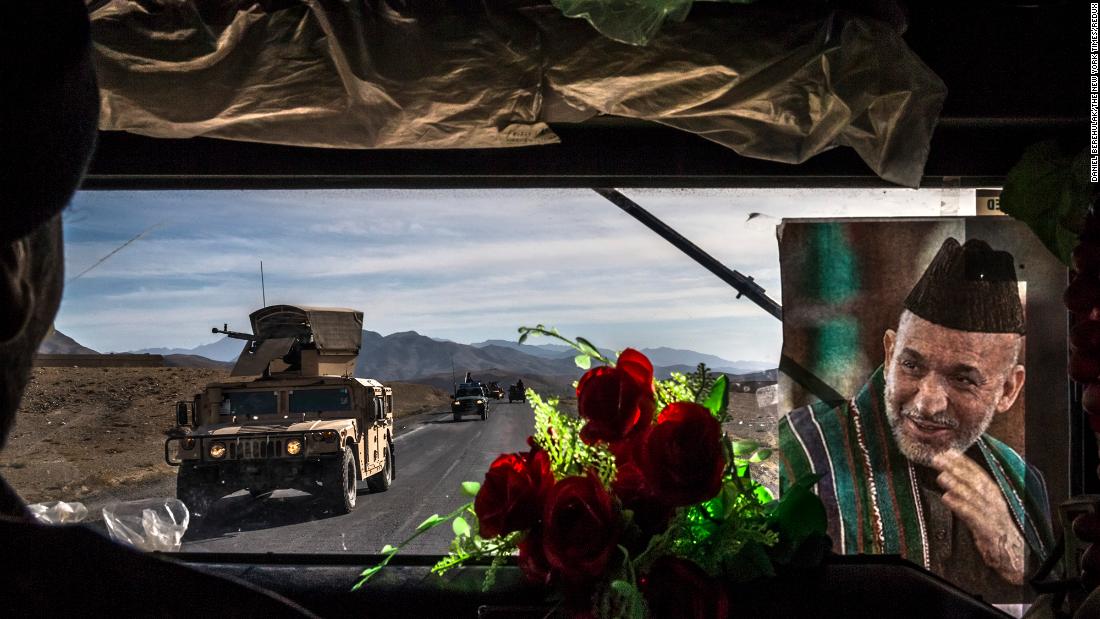 An Afghan army convoy travels Highway 1 in Afghanistan&#39;s Wardak province in November 2013. The picture at right shows Afghan President Hamid Karzai.