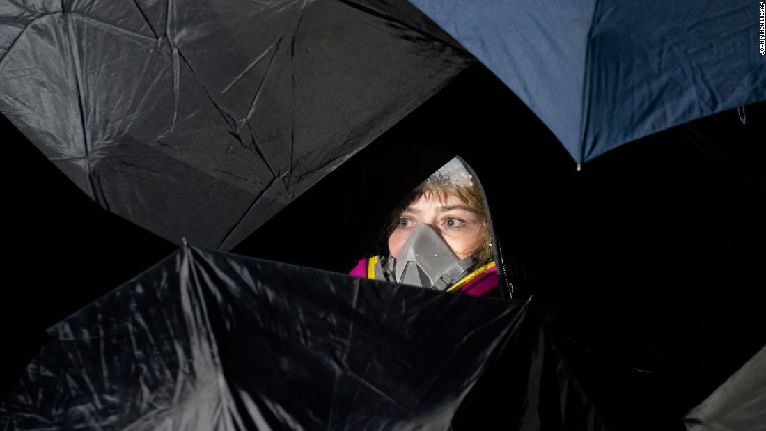 A demonstrator is seen behind umbrellas.