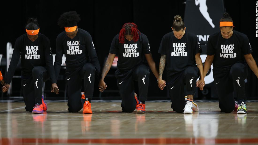 WNBA team the Connecticut Sun kneel during the National Anthem before the game against the Atlanta Dream in August 2020. The WNBA dedicated the season to Breonna Taylor and the Say Her Name movement -- which raises awareness for Black female victims of police violence. They also collectively backed Raphael Warnock in the Georgia senatorial elections against Republican and WNBA team -- the Atlanta Dream -- owner Kelly Loffler.