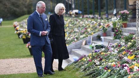 Le prince Charles et la duchesse de Cornouailles voient les fleurs et les messages de condoléances laissés à l'extérieur du palais de Buckingham.