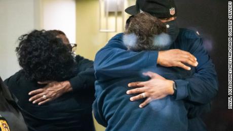 People hug after learning that their loved one is safe after a person shot and killed eight people inside a FedEx building in Indianapolis.