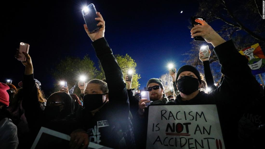 People hold their phones up while protesting outside the Brooklyn Center Police Department on Friday, April 16.