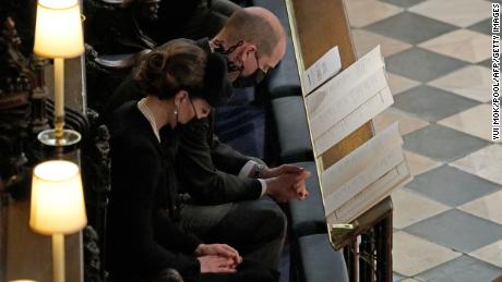 Prince William and his wife Catherine, the Duchess of Cambridge, bow their heads in prayer during the ceremony.