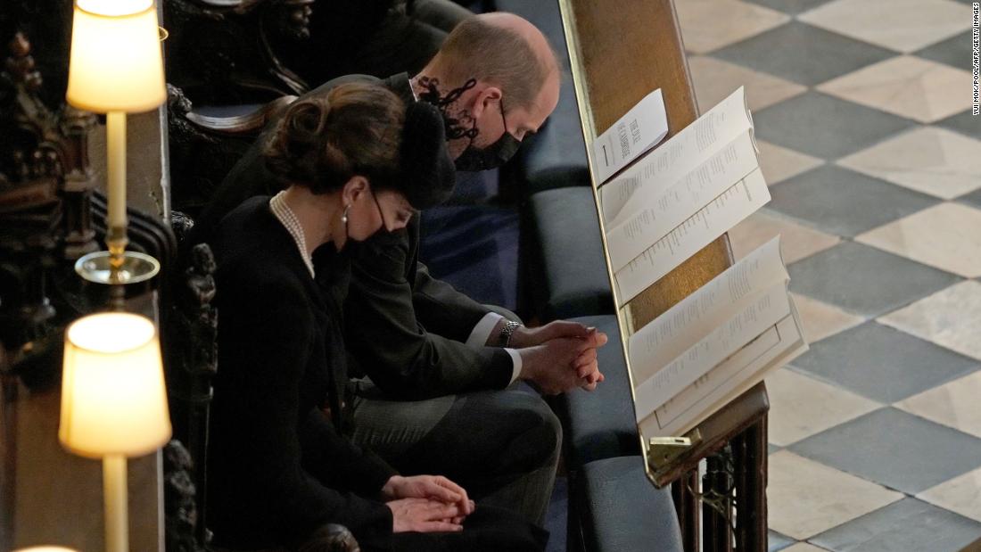 Prince William and his wife, Catherine, the Duchess of Cambridge, bow their heads in prayer during the ceremony.
