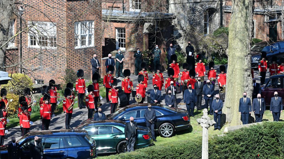 Drivers, Grenadier Guards and royal household staff stand outside during the funeral.