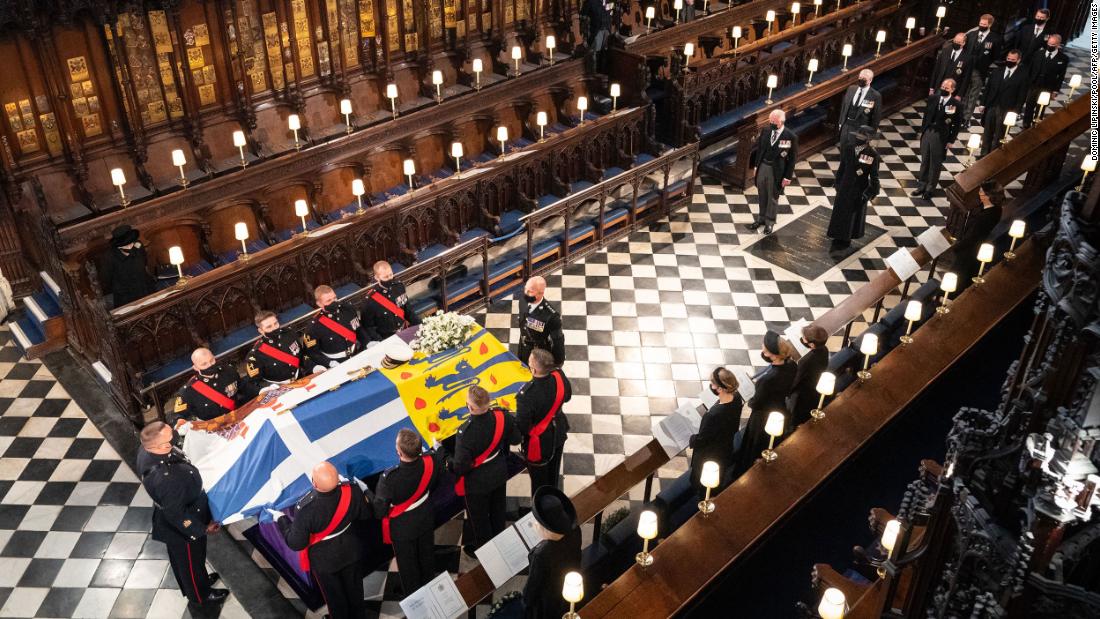 The Queen, left, watches as pallbearers carry Philip&#39;s coffin inside St. George&#39;s Chapel.