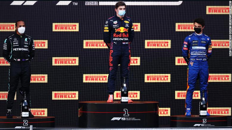 Lewis Hamilton, Max Verstappen and Lando Norris stand on the podium.