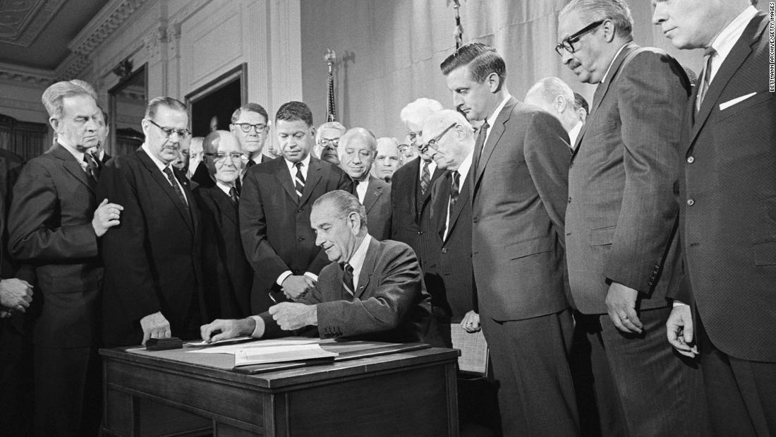 Mondale and other senators watch as Johnson signs the Civil Rights Act of 1968 into law on April 11, 1968.