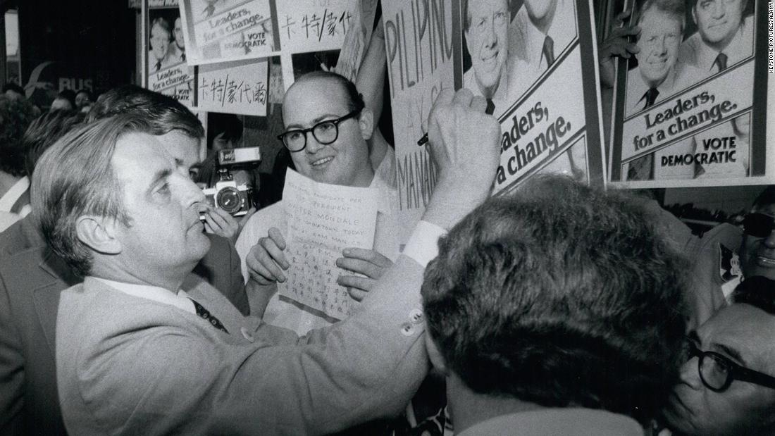 Mondale signs a poster of him and Carter while campaigning in New York on October 4, 1976.