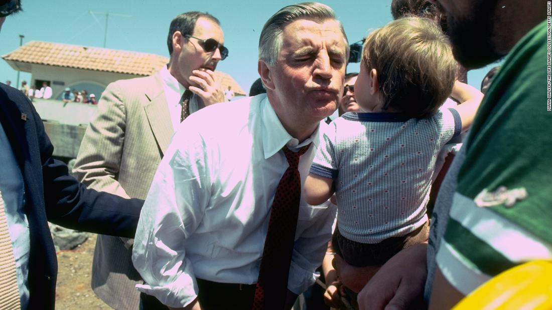 Mondale puckers up to kiss a child while campaigning in May 1984. 