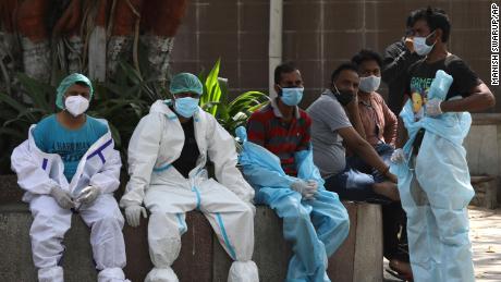 Des agents de santé se reposent entre les victimes d'incinération de Covid-19 à New Delhi, en Inde, le 19 avril.