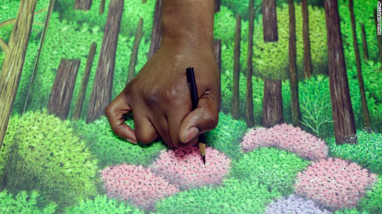 Dixon touches up a golf drawing he is creating in prison.