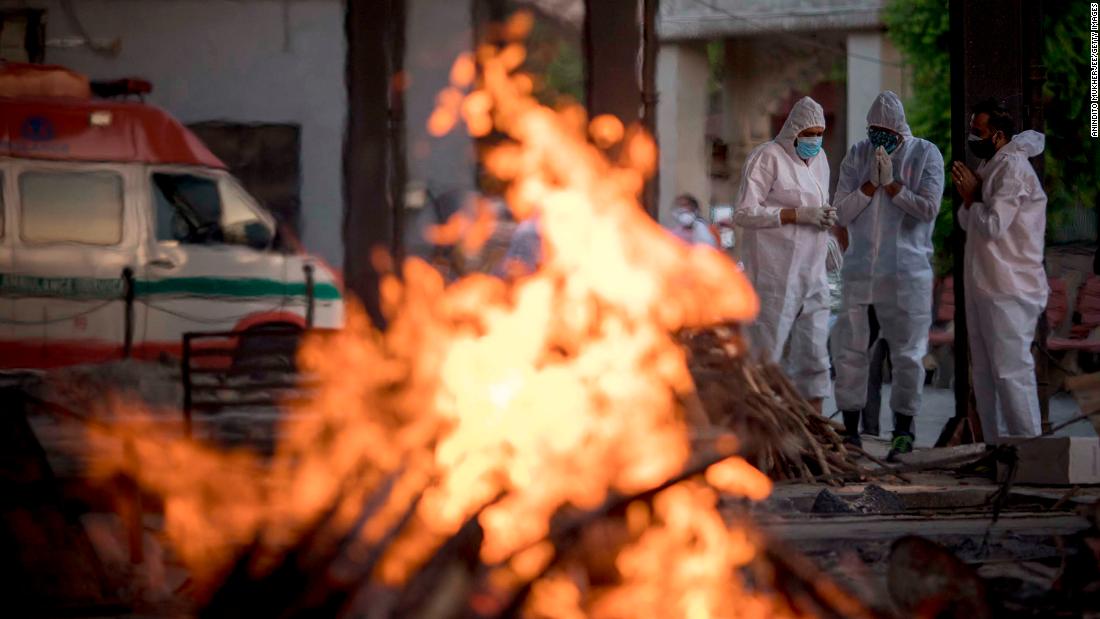 Relatives of a patient who died from Covid-19 perform his last rites amid other burning pyres at a crematorium in New Delhi.