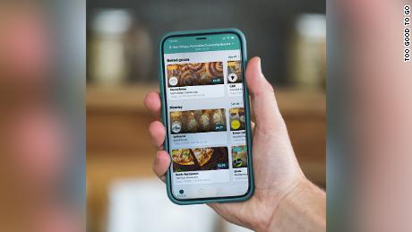 A user looking interacting with the Too Good To Go app on their phone.