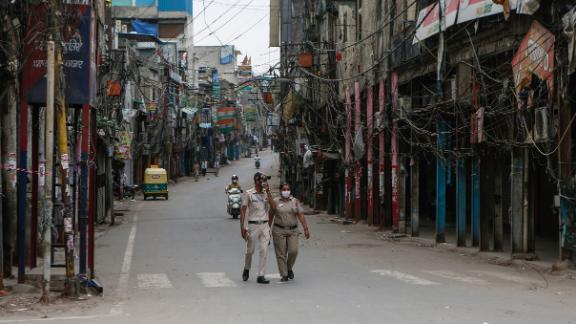 Police officers patrol a deserted street in New Delhi on April 20. The capital city has been on lockdown because of Covid-19.