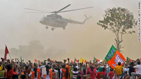 Supporters of Bharatiya Janata Party (BJP) wave at a helicopter carrying Indian Prime Minister Narendra Modi upon his arrival at a rally in Kawakhali, West Bengal, on April 10.