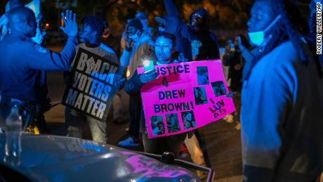 Police work to disperse demonstrators after they surrounded an Elizabeth City police car.