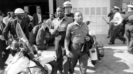 The Rev. Ralph Abernathy, left, and the Rev. Martin Luther King Jr. are led by a policeman as they are arrested in Birmingham, Alabama on April 12, 1963. King later spent days in solitary confinement writing his &quot;Letter From Birmingham Jail,&quot; which stirred the world by explaining why Black people couldn&#39;t keep waiting for fair treatment. 