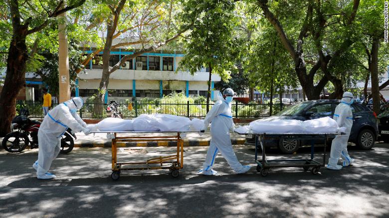 Health workers wearing personal protective equipment carry bodies of people who were suffering from Covid-19 outside the Guru Teg Bahadur hospital, in New Delhi, India, on April 24.