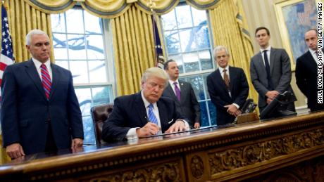 Former President Donald Trump signing an executive order alongside White House officials on January 23, 2017. Among three orders signed was one reinstating and expanding the Mexico City Policy.