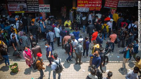 As pessoas esperam por uma viagem de ônibus para retornar às suas aldeias natais após novas restrições do governo em Kathmandu, Nepal, em 27 de abril.