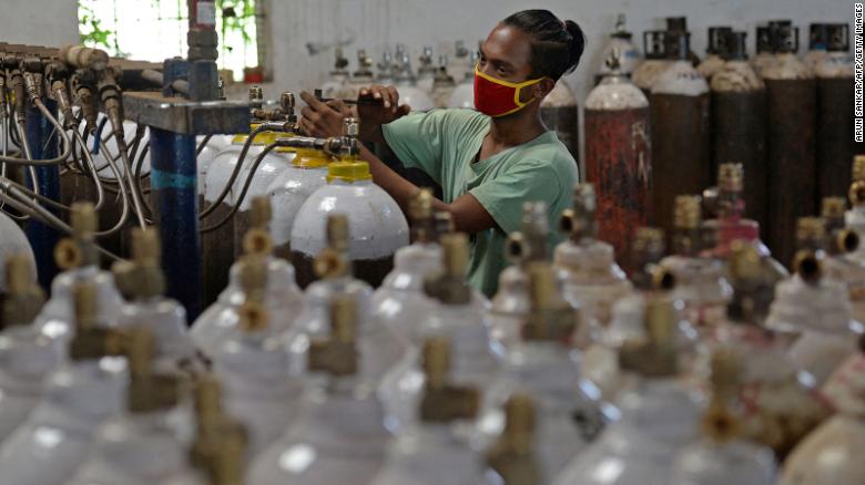 A worker fills medical oxygen cylinders on the outskirts of Chennai.