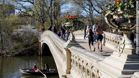 People stand on the Bow Bridge at Central Park on April 13 in New York City. The city is targeting a July 1 reopening.