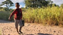 In the San village, children carry water from a nearby borehole. Activists and scientists fear that a large-scale oil industry here could pollute the ground water. ReconAfrica says their practices won't lead to water pollution.