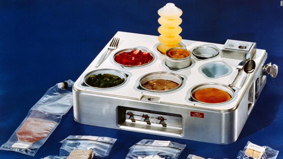 This food tray was used in the now-defunct Skylab, the first US space station launched by NASA in 1973. Shown in the tray are (counterclockwise from back): orange drink, strawberries, asparagus, prime rib, dinner roll and  butterscotch pudding.